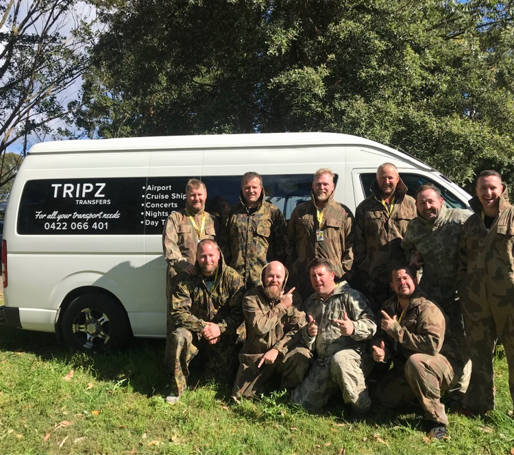 Bucks party group in paintball clothing beside the TRIPZ van