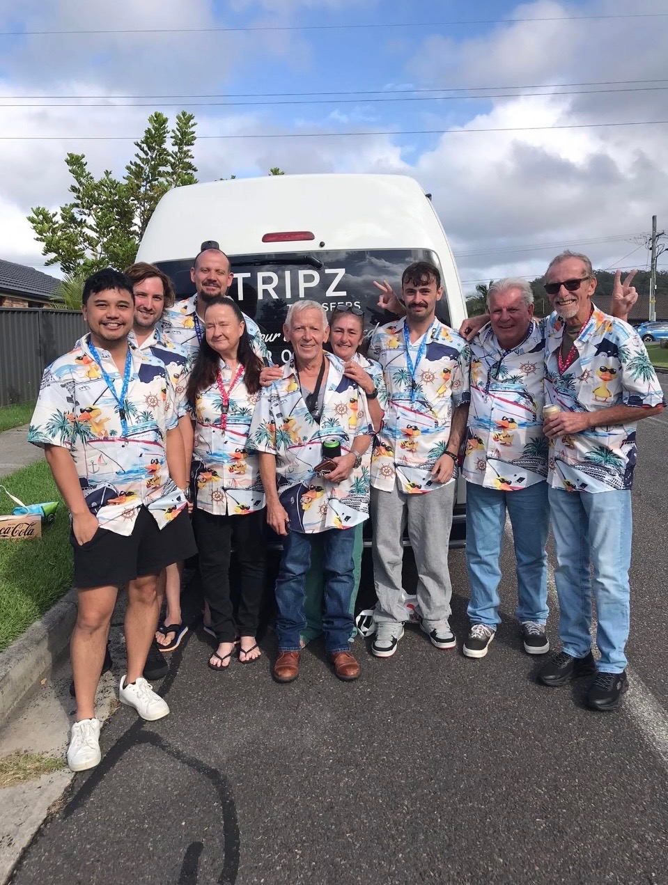 Regular cruising group in matching colourful shirts beside the TRIPZ van
