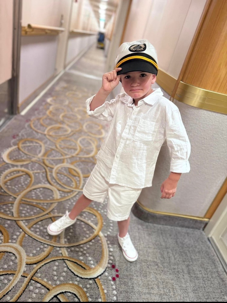 Child dressed in a captain’s outfit aboard a cruise ship