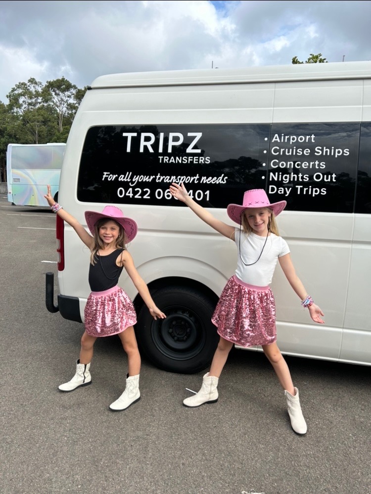 Two girls in pink cowboy hats beside the TRIPZ van for their first concert